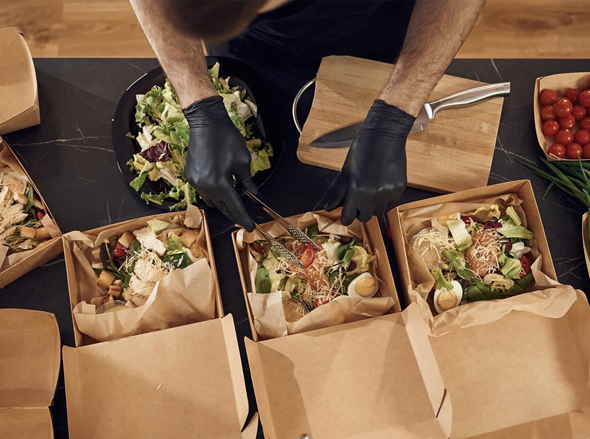 office lunch catering Catered lunch boxes neatly packed with sandwiches, and salad ready for individual serving at a corporate or group event.