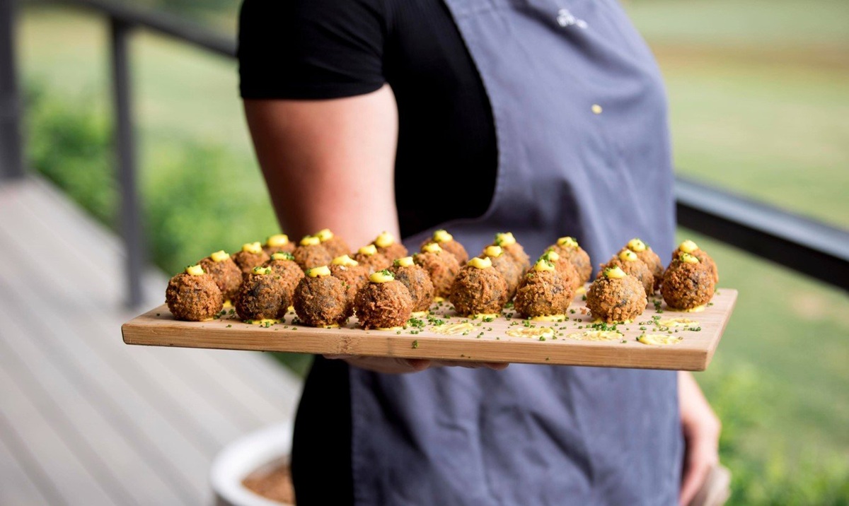 Arancini A waiter carries a tray of arancini, ready to serve guests.