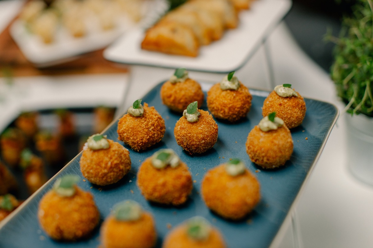 arancini catering A catering tray filled with golden-brown arancini.
